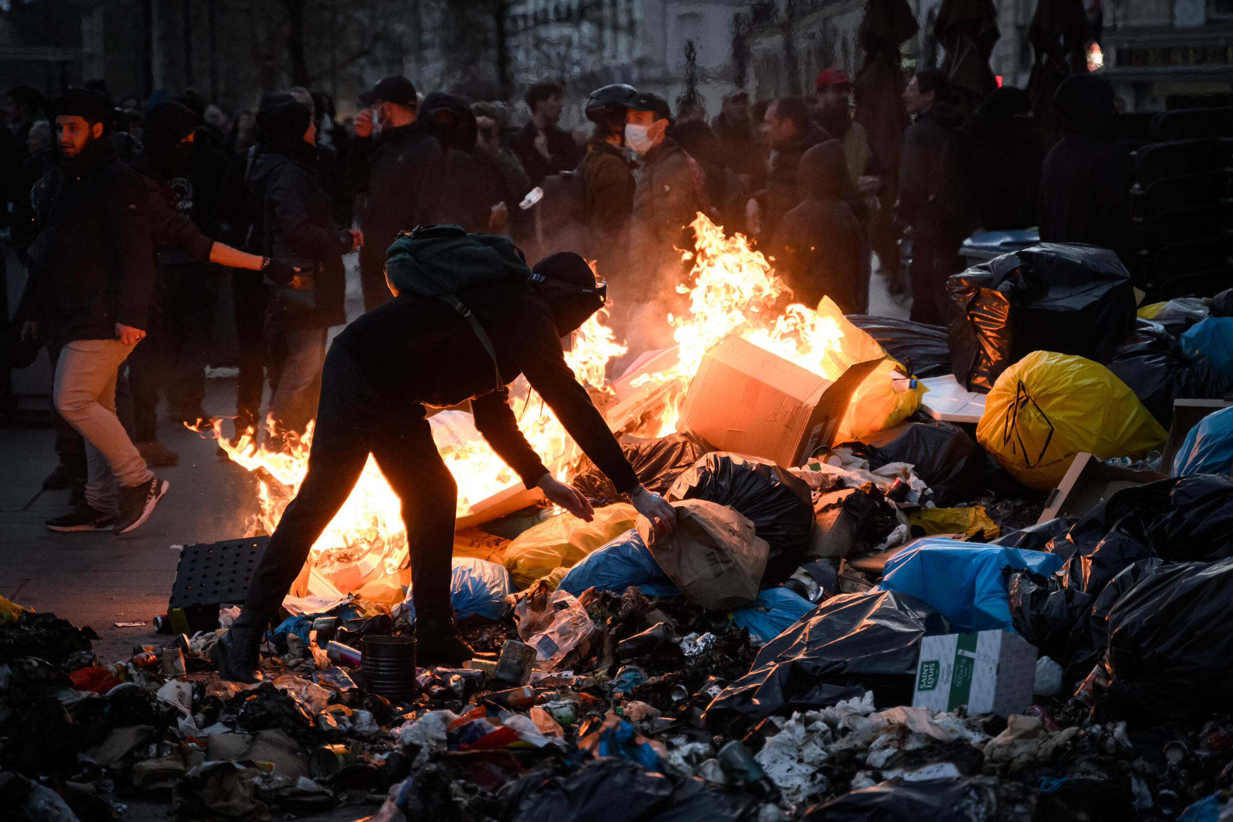 Un manifestante junto a basura en llamas durante una manifestación después de que el Gobierno francés aprobara una reforma a las pensiones en el Parlamento sin votación, utilizando el artículo 49.3 de la constitución. En Nantes, en el oeste de Francia, el 16 de marzo de 2023.