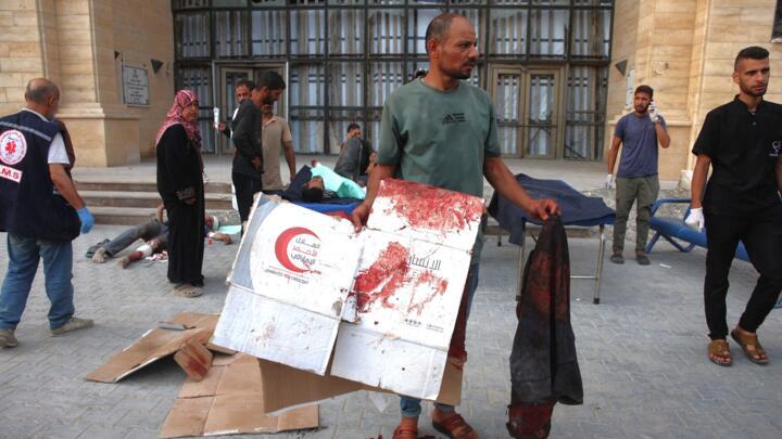 A man removes blood-stained items from outside the Hamad hospital in Gaza City on June 22, 2025, after humanitarian aid trucks entered the northern Gaza Strip through the Israeli-controlled Zikim bord