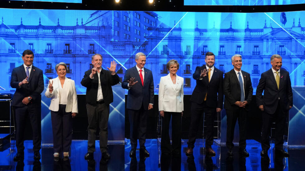 De izquierda a derecha, los candidatos presidenciales Franco Parisi, Jeannette Jara, Eduardo Artes, José Antonio Kast, Evelyn Matthei, Johannes Kaiser, Marco Enriquez-Ominami y el independiente Harold Mayne-Nicholls saludan antes de un debate previo a las elecciones generales de noviembre, en Santiago, Chile, el 26 de octubre de 2025.