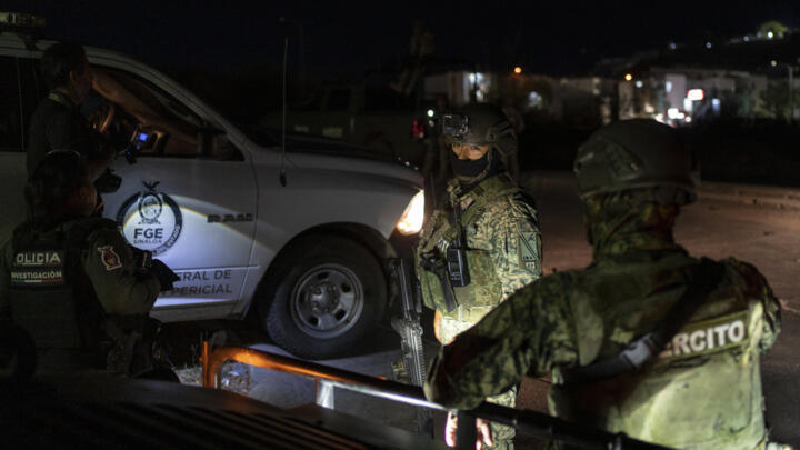 File photo taken May 20, 2025 of soldiers standing guard near a body found on a road in Culiacan, Sinaloa state, Mexico.