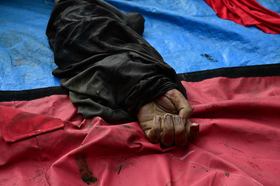 The hand of a dead man is seen among a line of bodies on Sao Lucas Square of the Vila Cruzeiro favela at the Penha complex in Rio de Janeiro, Brazil, on October 29, 2025, in the aftermath of Operacao Contencao (Operation Containment). Residents of a favela in Rio de Janeiro lined up more than 50 bodies at a plaza in their low-income neighborhood on Ocotber 29, a day after the bloodiest police operation in the city's history, AFP reported.