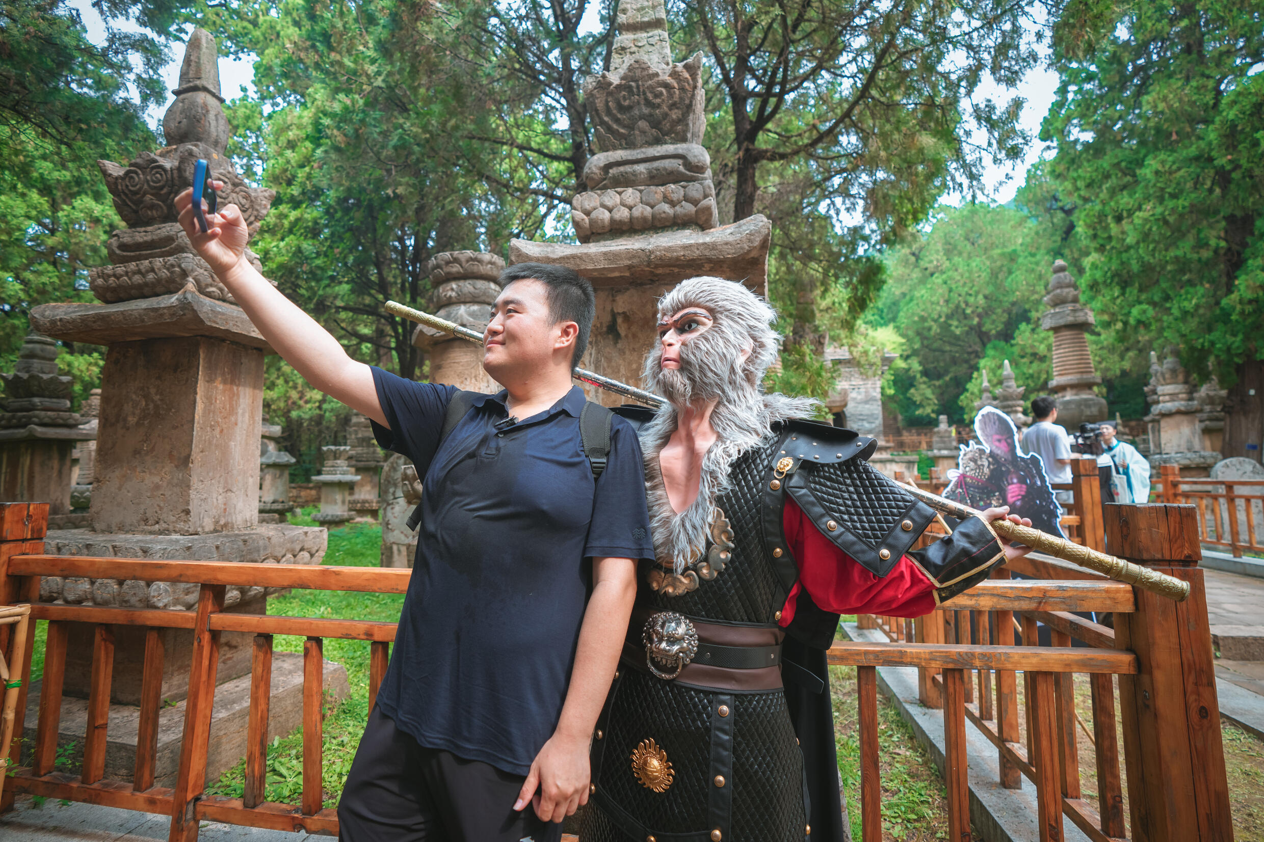 Un acteur déguisé en Roi singe acceuille des touristes au temple de Lingyan qui a été reproduit dans le jeu vidéo à succès Black Myth : Wukong.