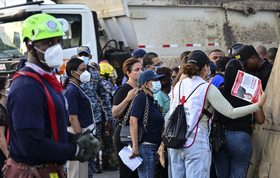 Varias personas esperan fuera de la discoteca Jet Set tras el derrumbe de su techo en Santo Domingo el 9 de abril de 2025.