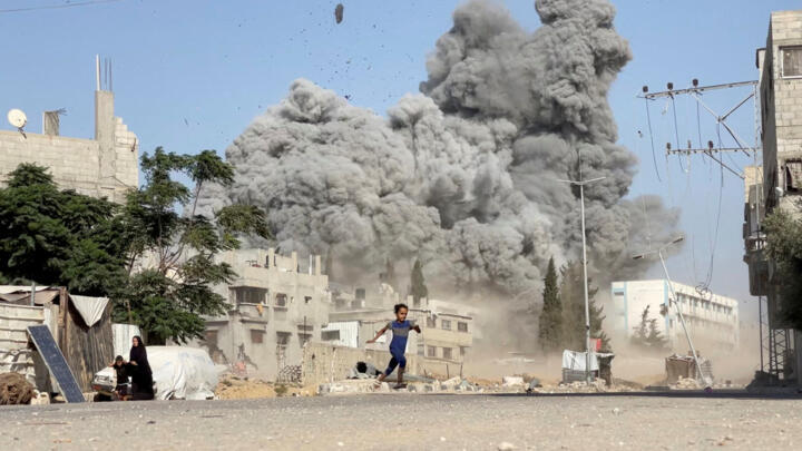 A girl runs from the scene after Israeli strikes on a school sheltering displaced people at the Bureij refugee camp in the central Gaza Strip, July 17, 2025.