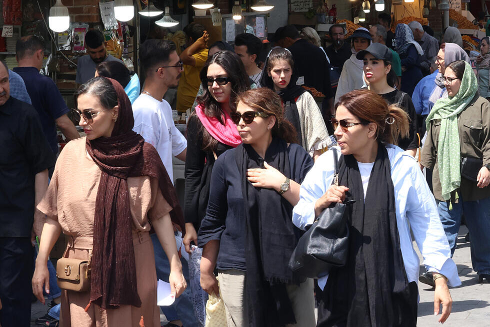 Iranian women walk past shops in the Grand Bazaar in Tehran on August 13, 2025. 