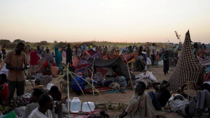 People sit at a camp for displaced families who fled from al-Fashir to Tawila in Sudan on October 27, 2025.