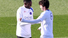 Paris Saint-Germain's French forward #10 Ousmane Dembélé (L) jokes with Paris Saint-Germain's Portuguese midfielder #87 Joao Neves during a training session at the Campus Paris Saint-Germain in Poissy