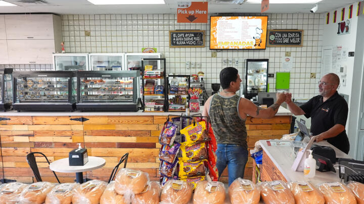 Dario Romero, right, co-owner of Venezuelan restaurant TeqaBite, greets a customer, Thursday, Aug. 21, 2025, in Kissimmee, Fla.
