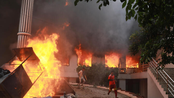Protesters run from the burning Nepali Congress Party office in Kathmandu on September 9.