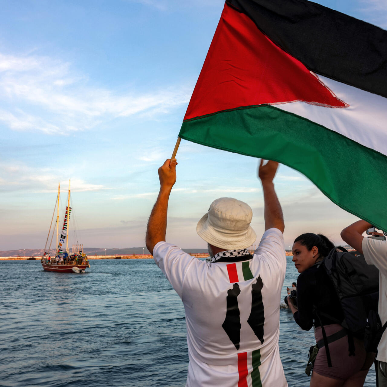 Activists on flotilla ship waving flags