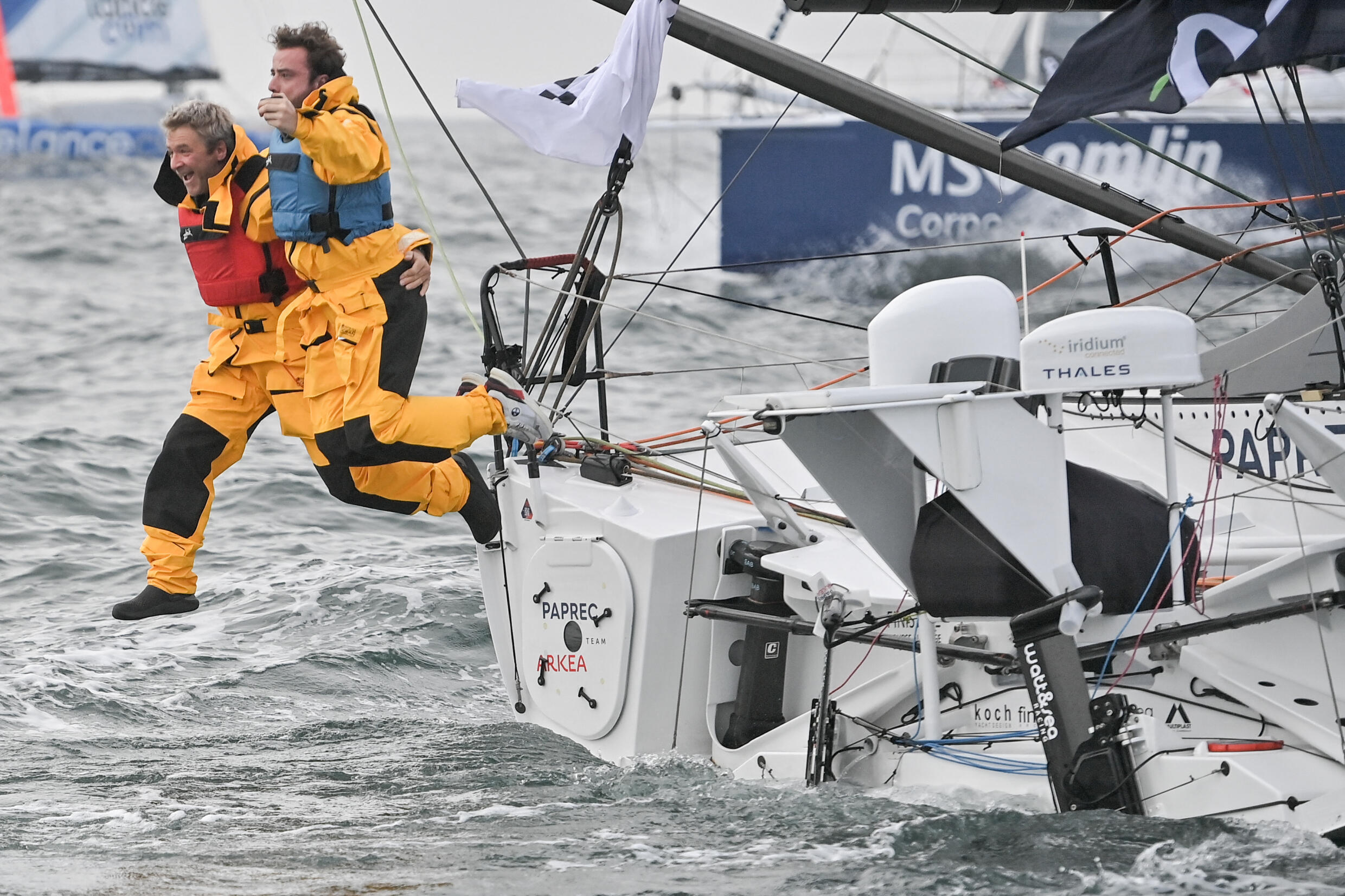 Le skipper français Yann Elies et un membre de l'équipe Paprec Arkea sautent dans la mer avant le départ du skipper français Yoann Richomme pour la 10e édition du Vendée Globe, dans l'ouest de la Fran