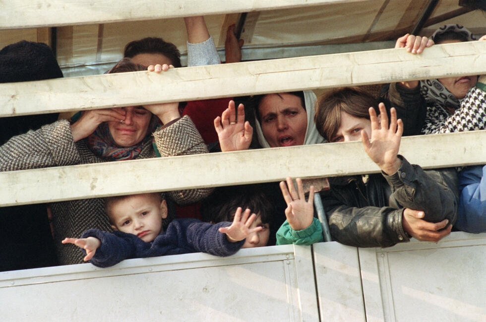 Des réfugiés musulmans à bord d'un convoi de l'ONU, alors qu'ils fuient l'enclave bosniaque de Srebrenica, assiégée par les Serbes, pour se rendre à Tuzla, le 31 mars 1993.