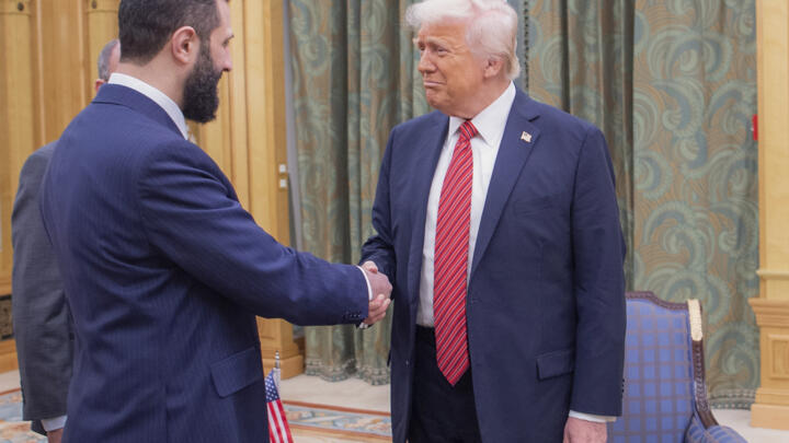 US President Donald Trump shakes interim Syrian President Ahmed al-Sharaa in Saudi Arabia on May 14, 2025.