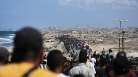 Displaced Palestinians walk along the coastal road near Wadi Gaza in the central Gaza Strip, moving toward northern Gaza, on October 10, 2025.