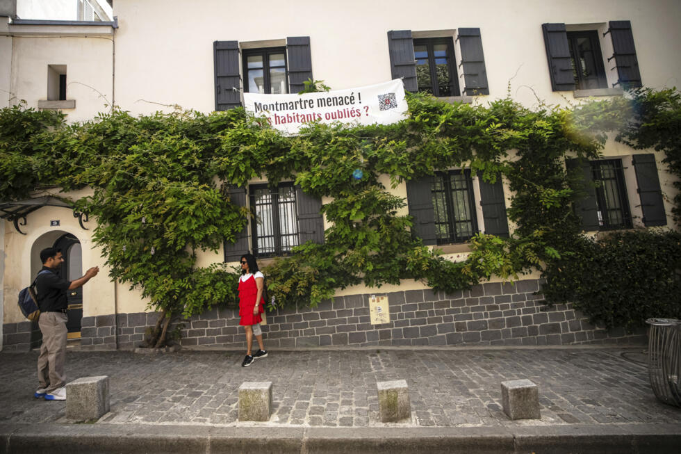 A banner reading "Montmartre under threat. Are residents being forgotten?" hangs at windows in the Montmartre district in Paris, France, on August 4, 2025.
