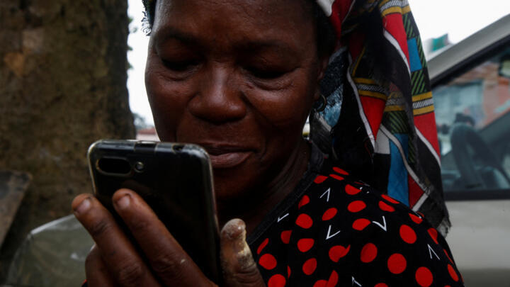 A woman looks at her smartphone in Ivory Coast.
