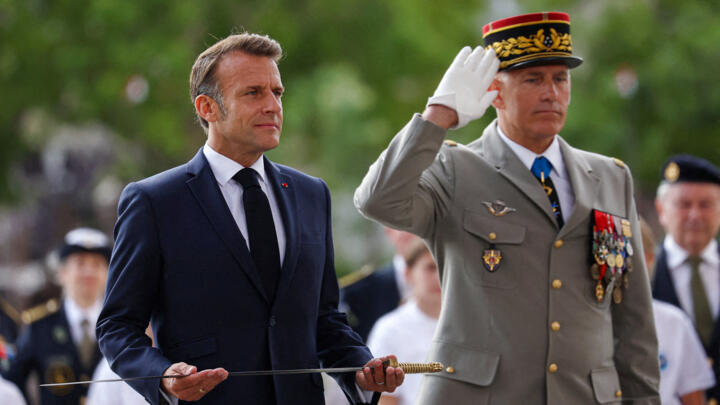 France's President Emmanuel Macron (L) presents a new sword to the Flame of the Unknown Soldier Committee flanked by French Military Governor of Paris (GMP) Loic Mizon