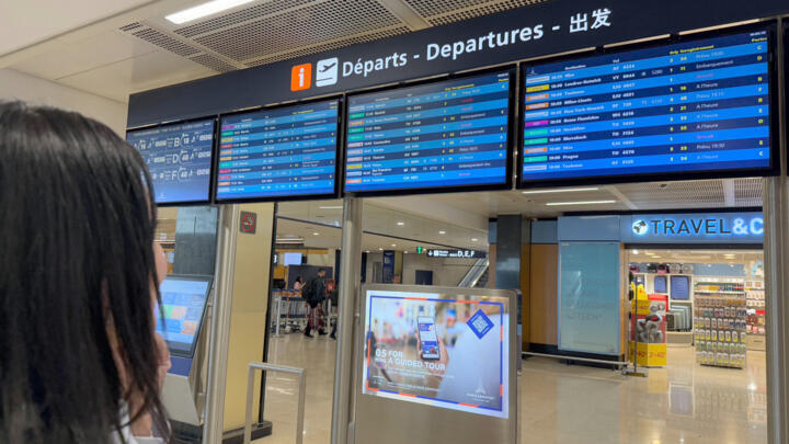 A traveller looks at flights information boards during a breakdown in air traffic control systems at Paris-Orly airport on May 18, 2025.