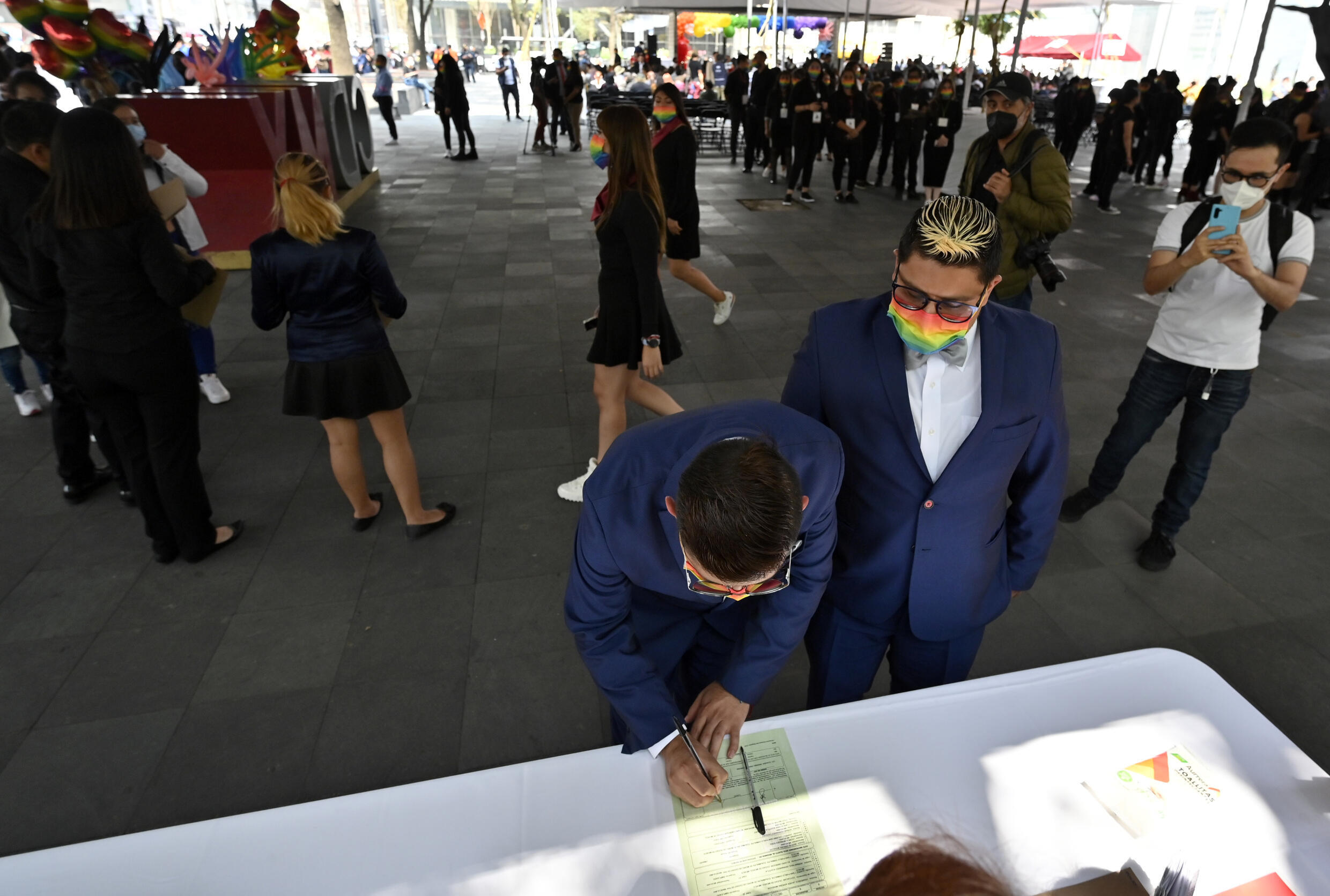 Una pareja firma documentos durante una boda colectiva igualitaria en el marco del mes del orgullo LGBTQ+ en Ciudad de México, el 24 de junio de 2022
