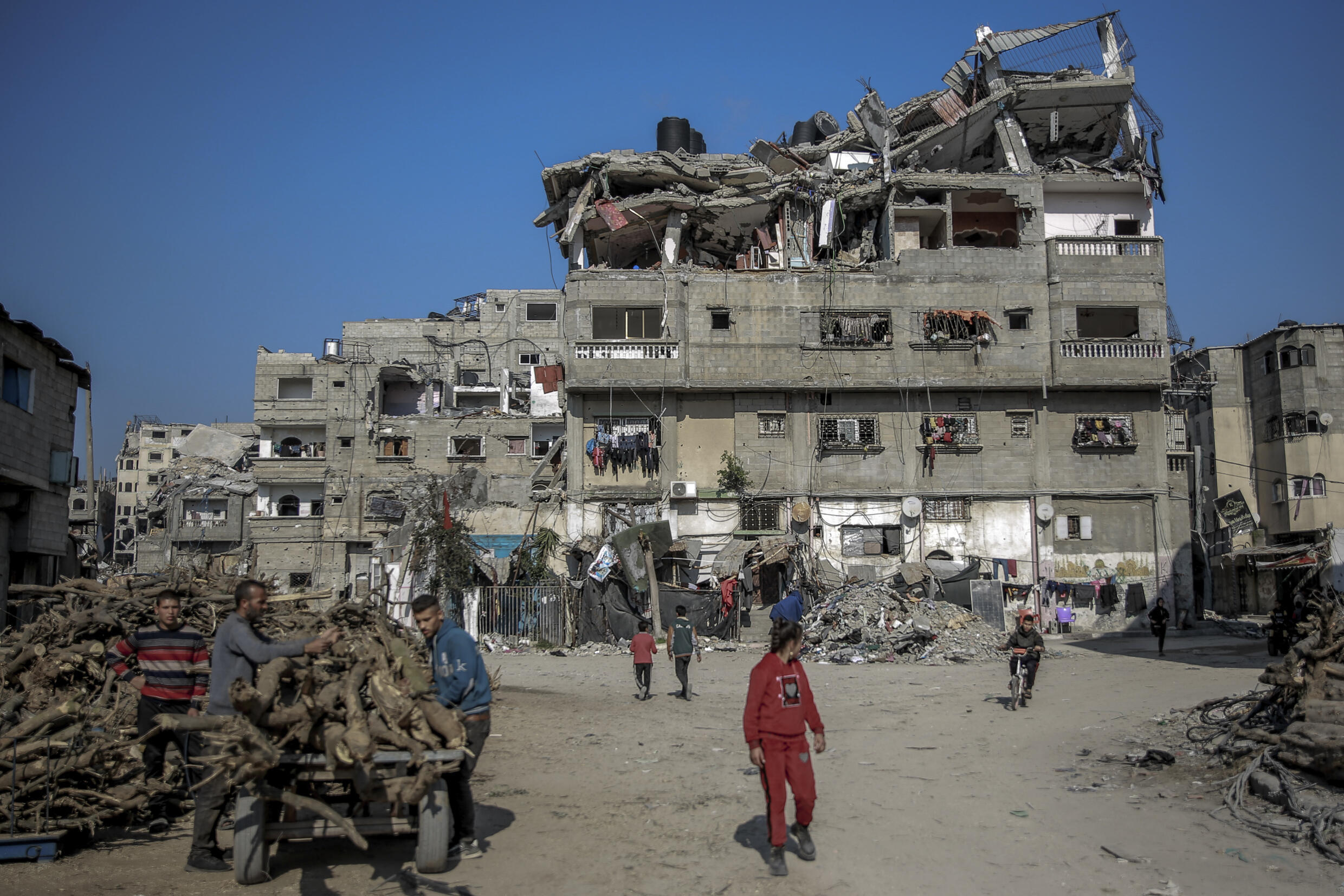 Des Palestiniens entassent du bois près d'un immeuble détruit lors de frappes isréaliennes, le 26 février 2024 à Beit Lahia dans la bande de Gaza