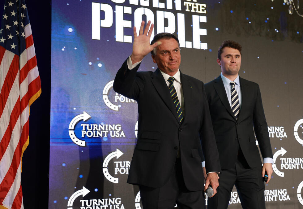 L'ancien président brésilien d'extrême droite Jair Bolsonaro salue la foule aux côtés de Charlie Kirk, cofondateur de Turning Point USA, lors de l'événement Turning Point USA, le 3 février 2023 à Dora