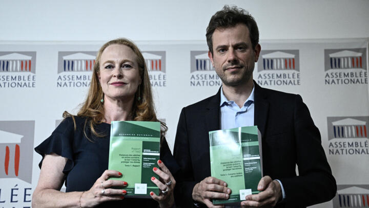 Commission's rapporteurs Paul Vannier (R) and Violette Spillebout (L) show the report of the parliamentary commission on violence in schools after a press conference at the National Assembly, in Paris