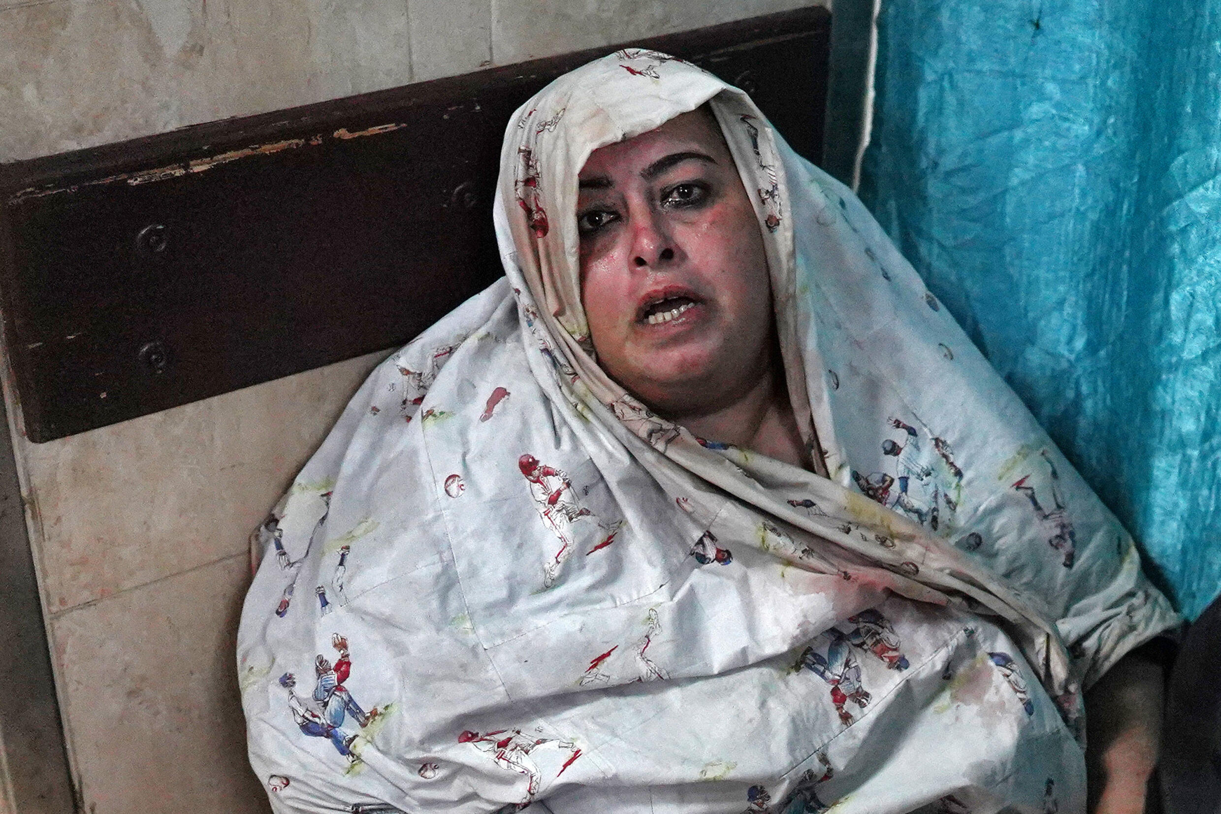 Une femme est assise par terre dans l'hôpital des martyrs d'Aqsa à Deir al-Balah, dans le centre de la bande de Gaza, le 4 juin 2024, après un bombardement israélien à al-Bureij, sur fond de guerre entre Israël et le mouvement islamiste palestinien Hamas