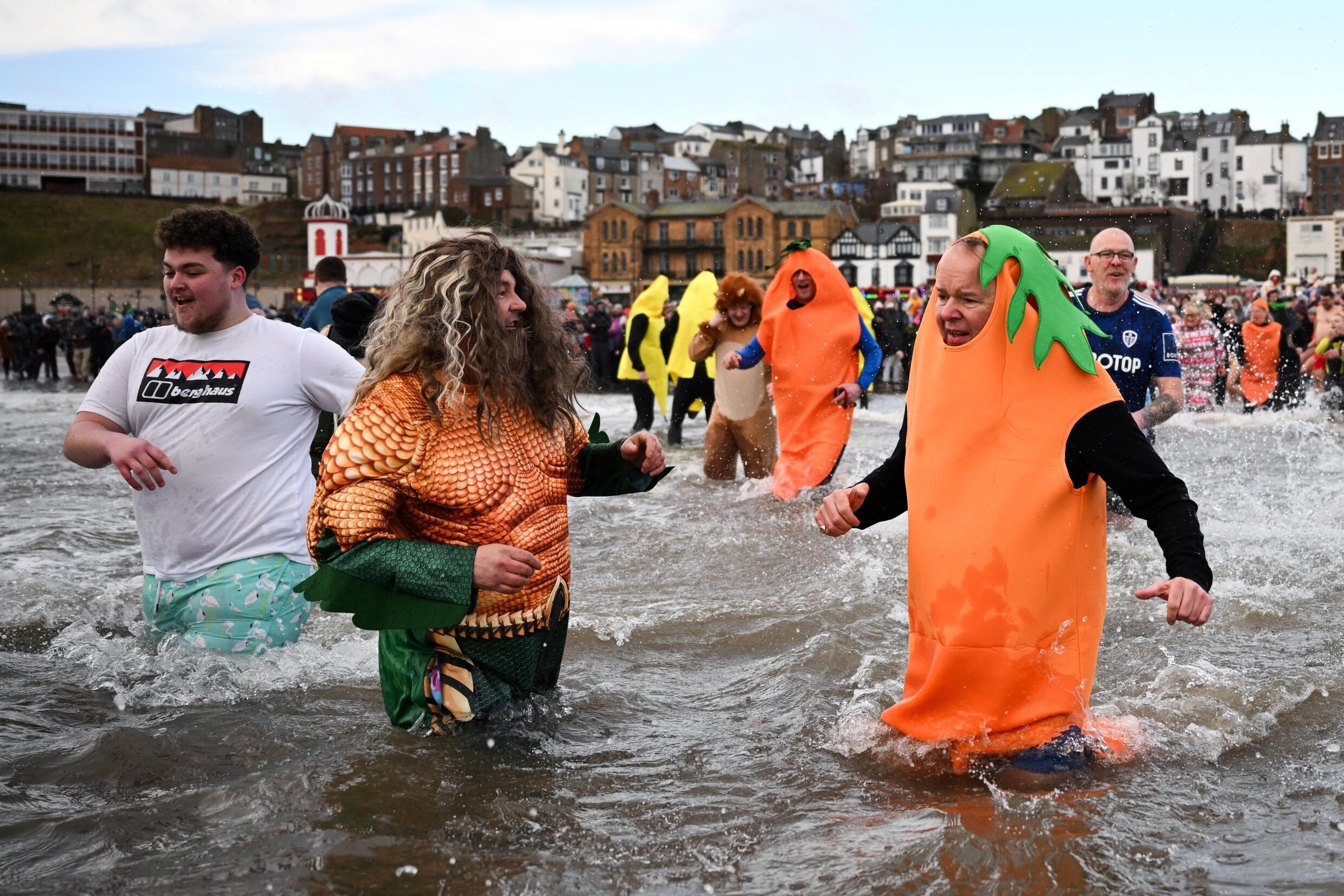 Des participants déguisés lors de l’événement caritatif New Year's Day Dip à South Bay s'amusent dans la mer du Nord, à Scarborough, dans le nord-est de l'Angleterre, le 1er janvier 2025.