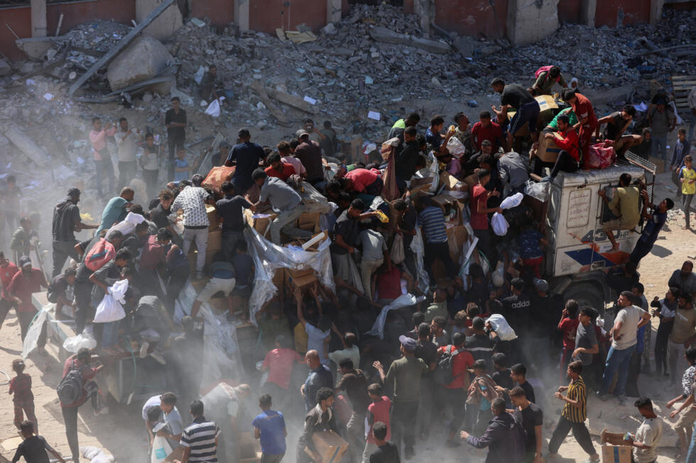 Des Palestiniens se précipitent sur un camion d'aide humanitaire à Khan Younès, dans le sud de la bande de Gaza, le 12 octobre 2025.