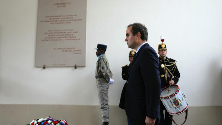 French Armies Minister Sebastien Lecornu (R) stands at attention during a wreath laying ceremony to pay tribute to late French army officer Alfred Dreyfus, of Jewish ancestry (1859-1935), on November