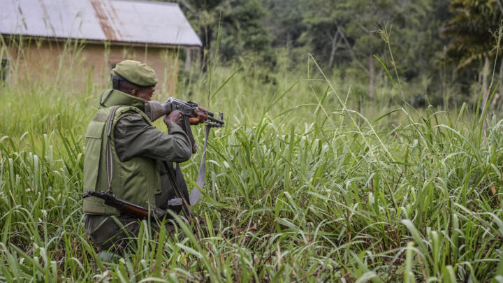 A soldier of the FARDC (Armed Forces of the Democratic Republic of the Congo) takes cover during exchanges of fire with members of the ADF (Allied Democratic Forces) in Opira, North Kivu, on January 25, 2018.