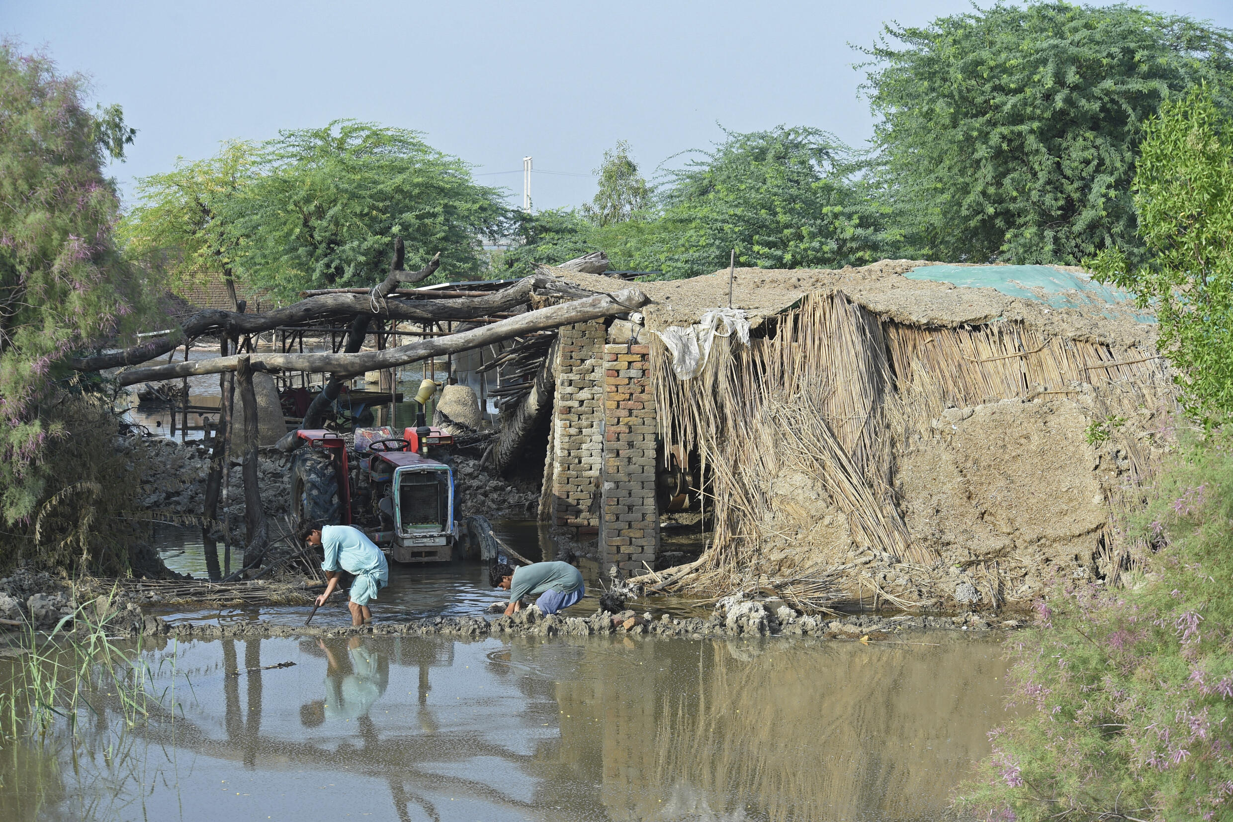 Víctimas de las inundaciones en Pakistán intentan evitar que el agua entre en sus casas en la región de Sindh el 30 de agosto de 2022.
