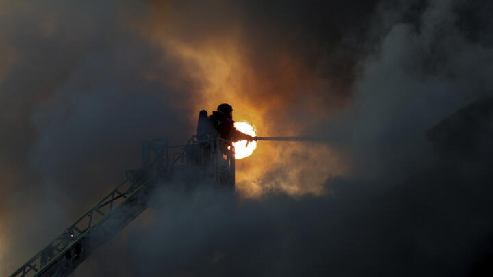 A rescue worker puts out a fire of a humanitarian aid storage destroyed by a Russian drone strike in Zaporizhzhia, Ukraine, on Saturday, June 14, 2025. 