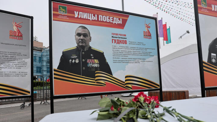 Flowers placed in front of a board with a photograph of Major General Mikhail Gudkov in Russia's far eastern city of Vladivostok on July 3, 2025.