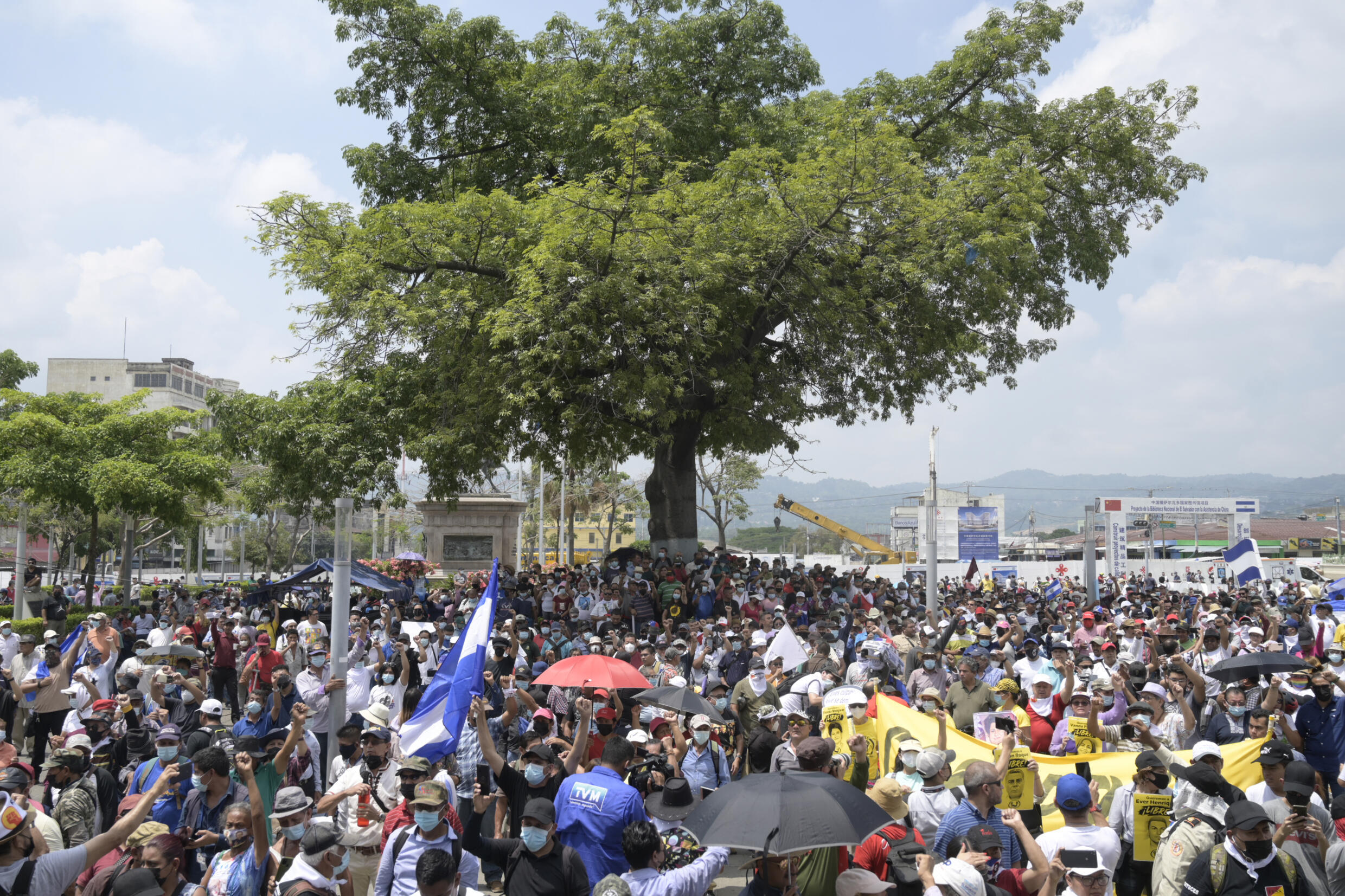 Miembros de organizaciones civiles, trabajadores y militares en retiro marchan en la capital San Salvador, este 1 de mayo, en medio del estado de emergencia impuesto por el gobierno