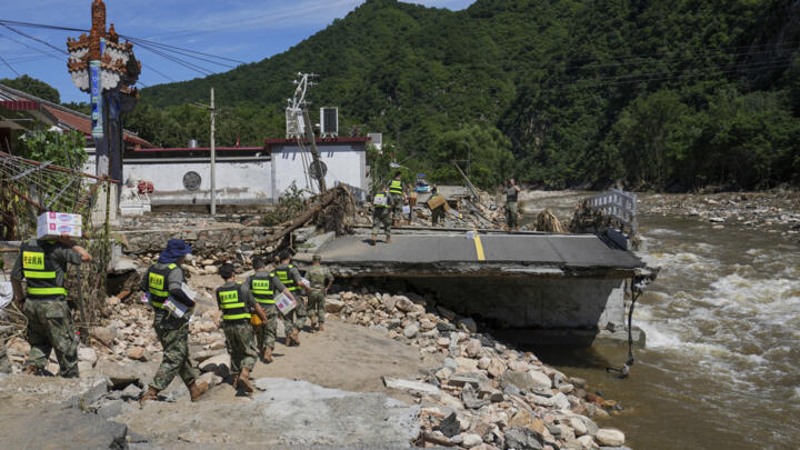 Soldiers carry relief supplies for trapped villagers in Miyun district on the outskirts of Beijing on July 30, 2025.