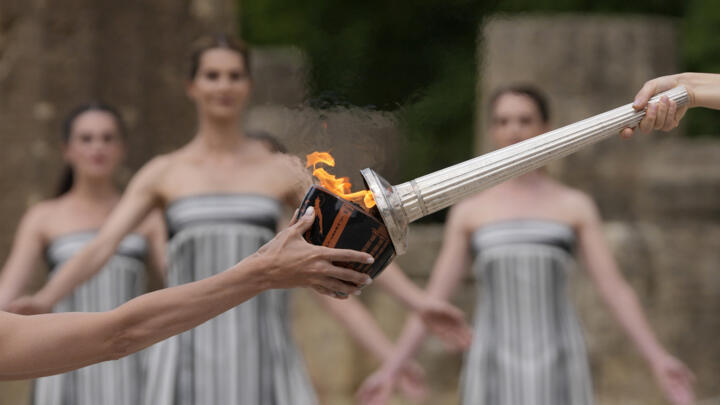 Greek actress Mary Mina, playing high priestess, lights a torch during the Olympic flame-lighting ceremony in Greece's ancient Olympia on April 16, 2024.