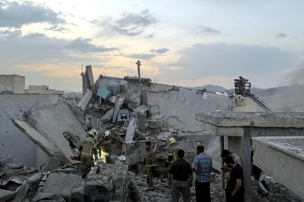 People and first-responders gather atop a building that was hit by an Israeli strike in Tehran on June 13, 2025.