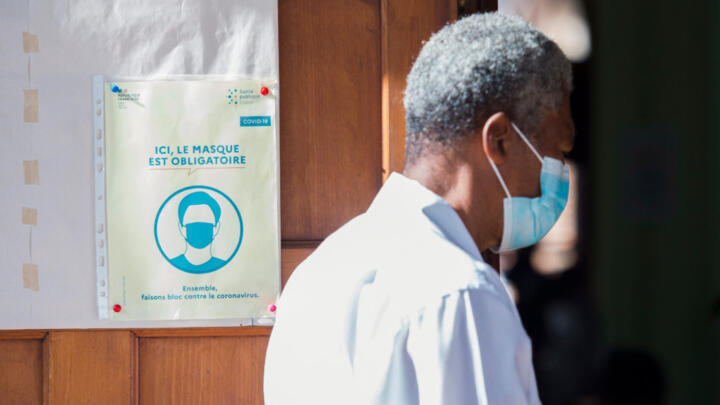 A worshipper passes by a Covid-19 information sign while stepping in Notre-Dame-de-la-Nativite church of Schoelcher, in the French Caribbean island of Martinique.