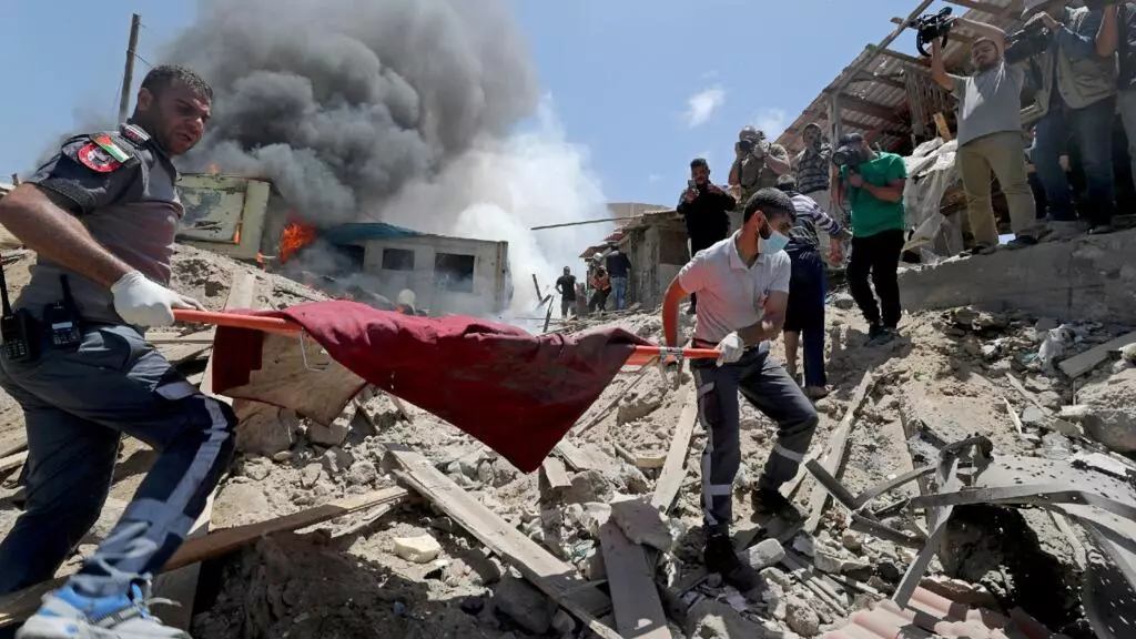 Palestinos evacuan un cuerpo del sitio de los ataques israelíes en la ciudad de Gaza 17 de mayo de 2021.