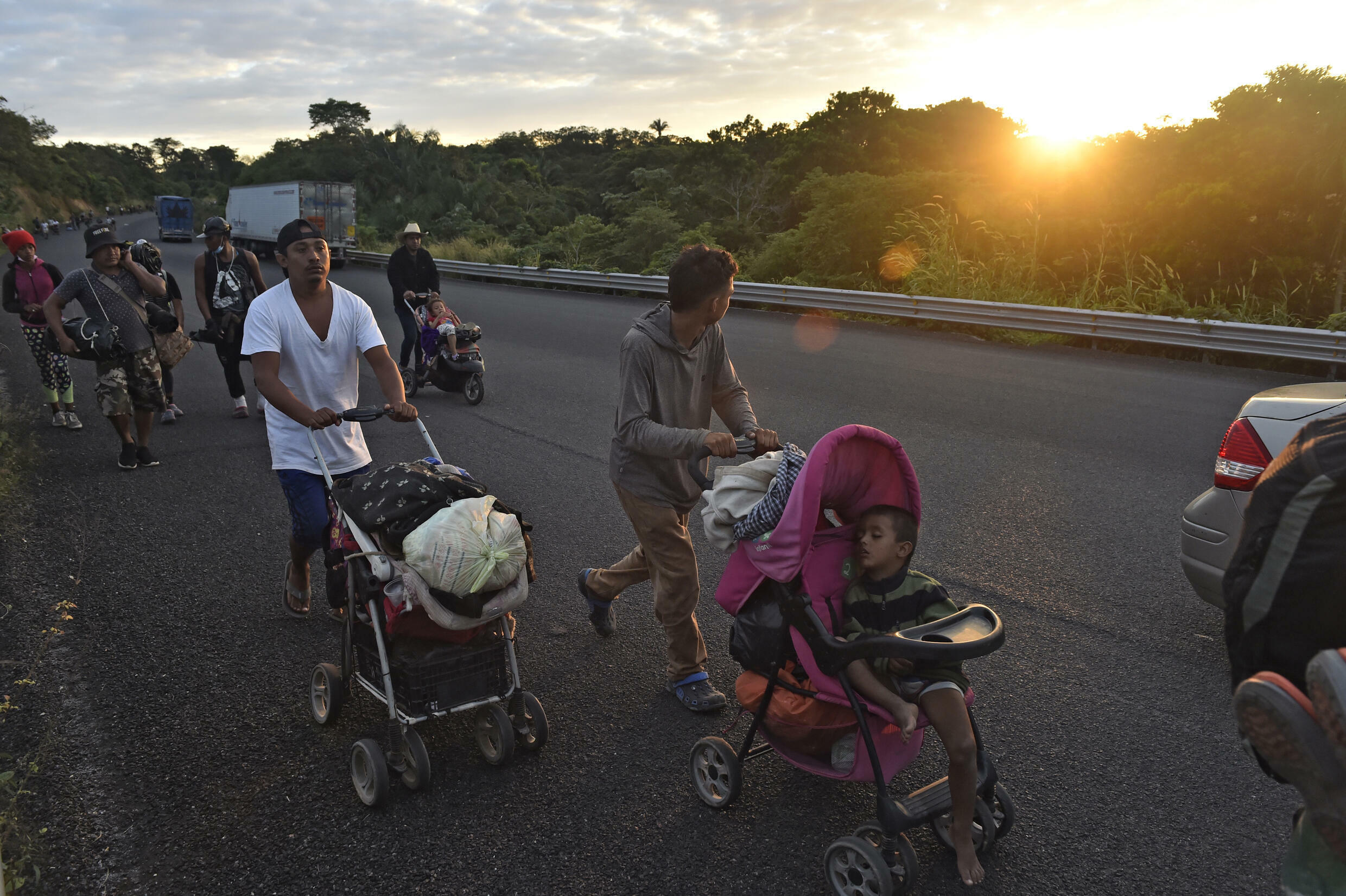 US-bound migrants traveling in a caravan walk along a highway in Mexico's southern state of Oaxaca