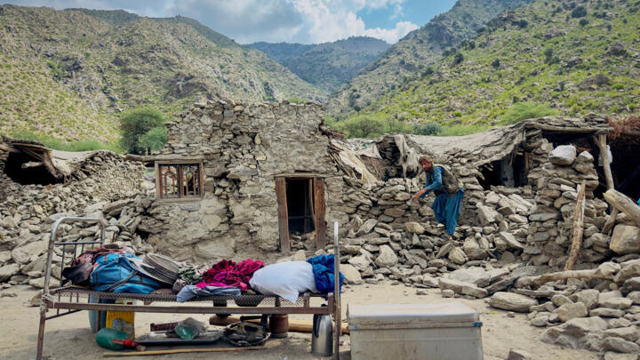 An Afghan man looks for his belongings amidst the rubble of his collapsed house after a deadly magnitude 6 earthquake that struck Afghanistan on Sunday, at Lulam village, in Nurgal district, Kunar pro