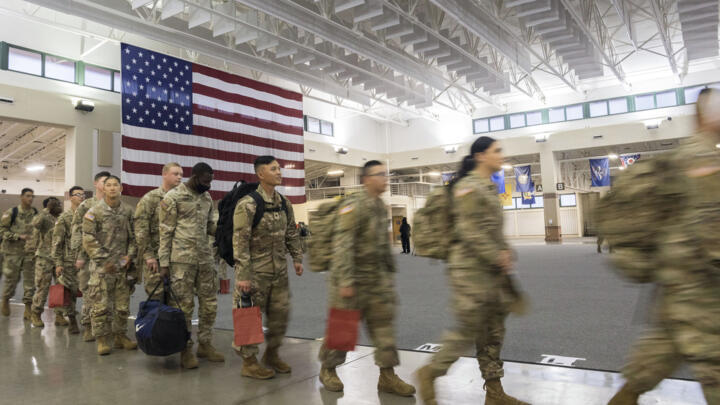 US soldiers wait to board a chartered plane during their deployment to Europe on Friday, March 11, 2022, at Hunter Army Airfield in Savannah, Georgia. 
