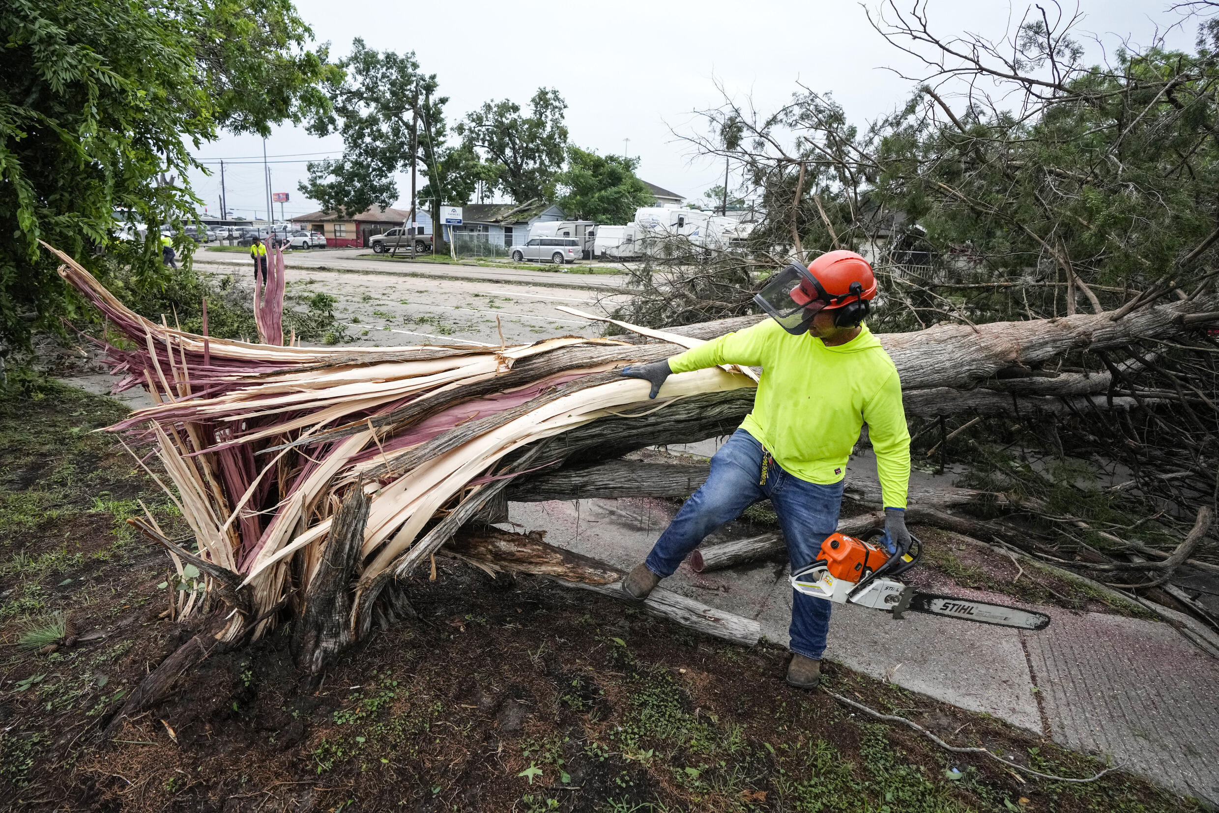 Dionysius Torreros, de la ciudad de Houston, trabaja en la limpieza de un árbol que se desplomó sobre Bingle Road tras una fuerte tormenta el viernes 17 de mayo de 2024, en Houston. La destrucción generalizada paralizó gran parte de Houston mientras los equipos se apresuraban a restablecer el suministro eléctrico y retirar los árboles arrancados y los escombros.