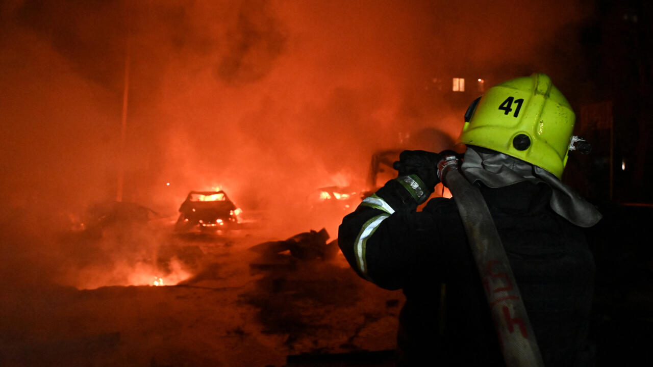 A Ukrainian firefighter uses a water hose to extinguish a fire at the site of a Russian strike in Kharkiv, early on November 19, 2025, amid the Russian invasion of Ukraine. An overnight Russian drone strike wounded at least 36 people in Ukraine's Kharkiv, authorities said on November 19, 2025, the third such attack on the eastern region in three days.