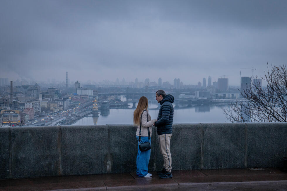 A couple stands on a bridge in Kyiv, Ukraine on December 1, 2025.