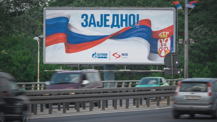 Cars pass a billboard depicting the Russian and Serbian flags with the Cyrillic writing, "Together!" in Belgrade on June 2, 2022.