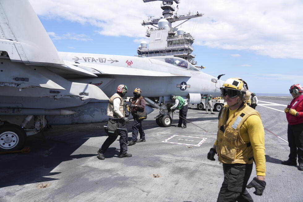Un oficial pasa junto a un F-18 Super Hornet en la cubierta de vuelo del portaaviones USS Gerald R. Ford durante ejercicios militares en el Mediterráneo. Nápoles, Italia, 29 de julio de 2025.