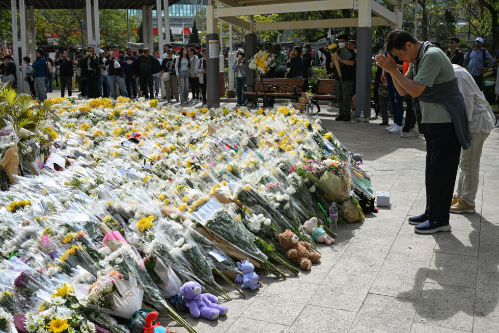 People lay flowers in front of the Wang Fuk Court residential buildings on 1 December 2025, following the deadly fire that ravaged Hong Kong's Tai Po district.