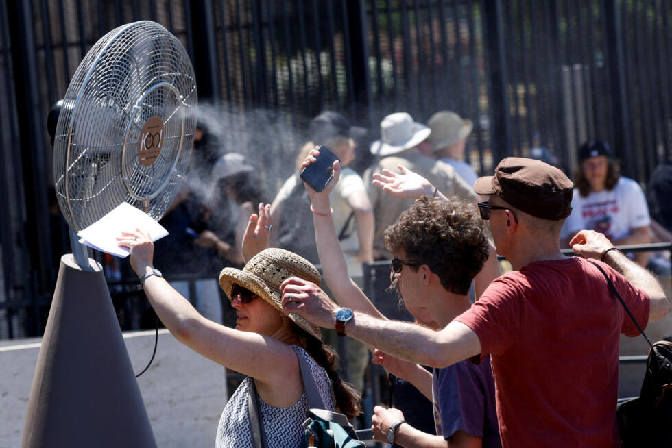 Turistas frente a un ventilador instalado en el exterior del Coliseo durante la ola de calor en Roma, Italia, 30 de junio de 2025.